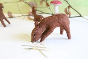 Handmade little felt grazing doe